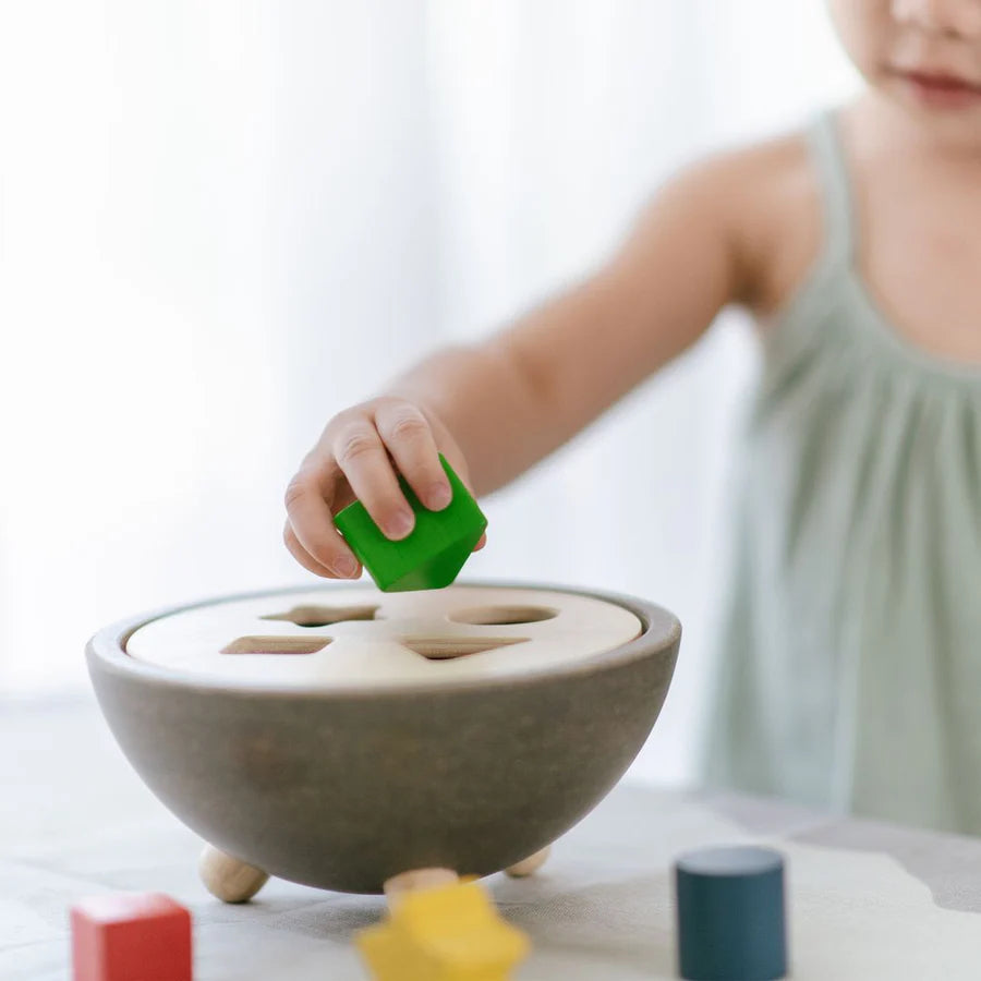 Child playing with shape sorting bowl