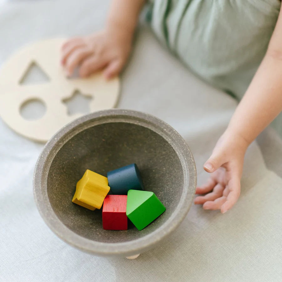 Child playing with shape sorting bowl