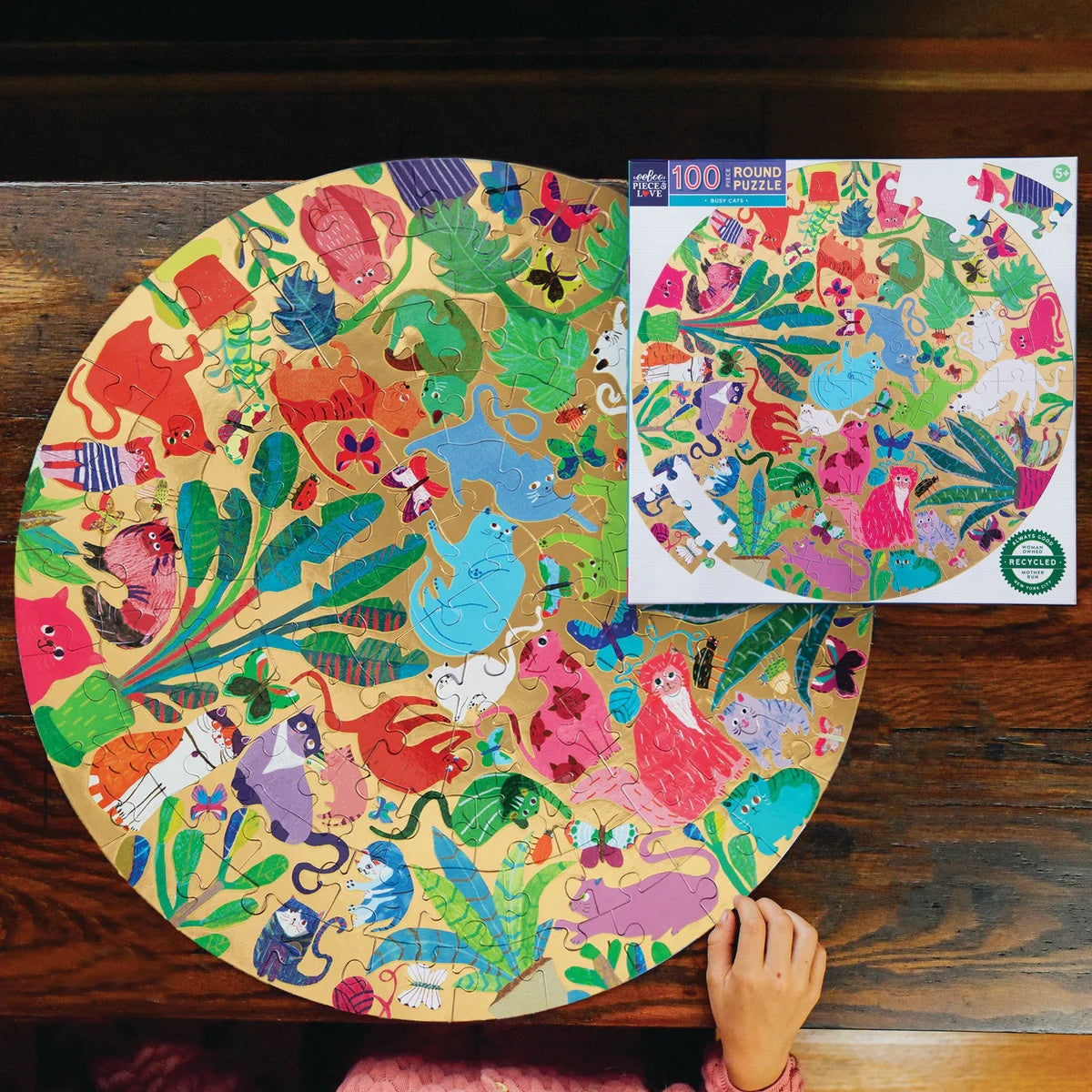 Completed Busy Cats round puzzle on a wooden table
