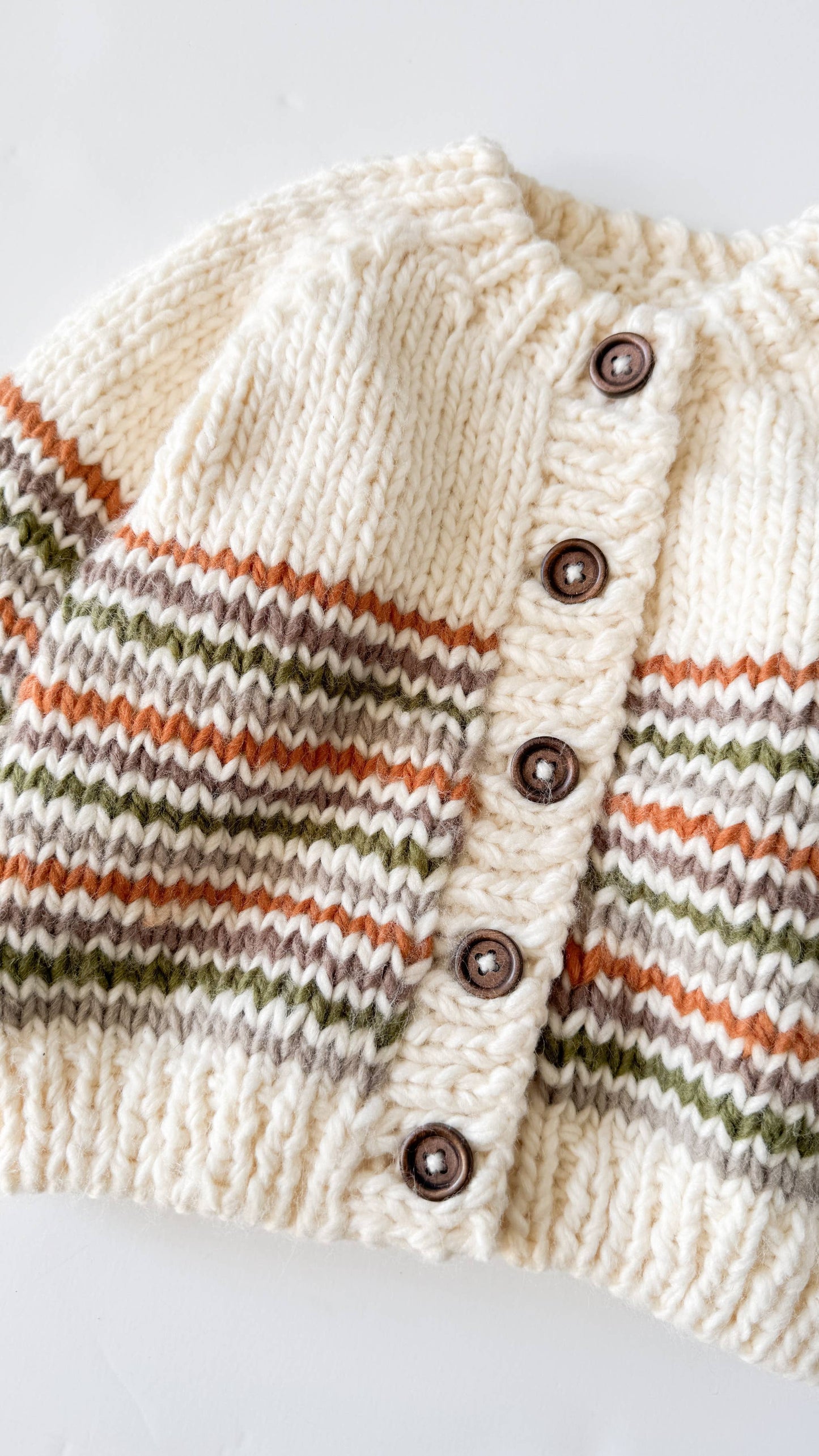 Knitted cardigan with striped pattern and buttons on a white background