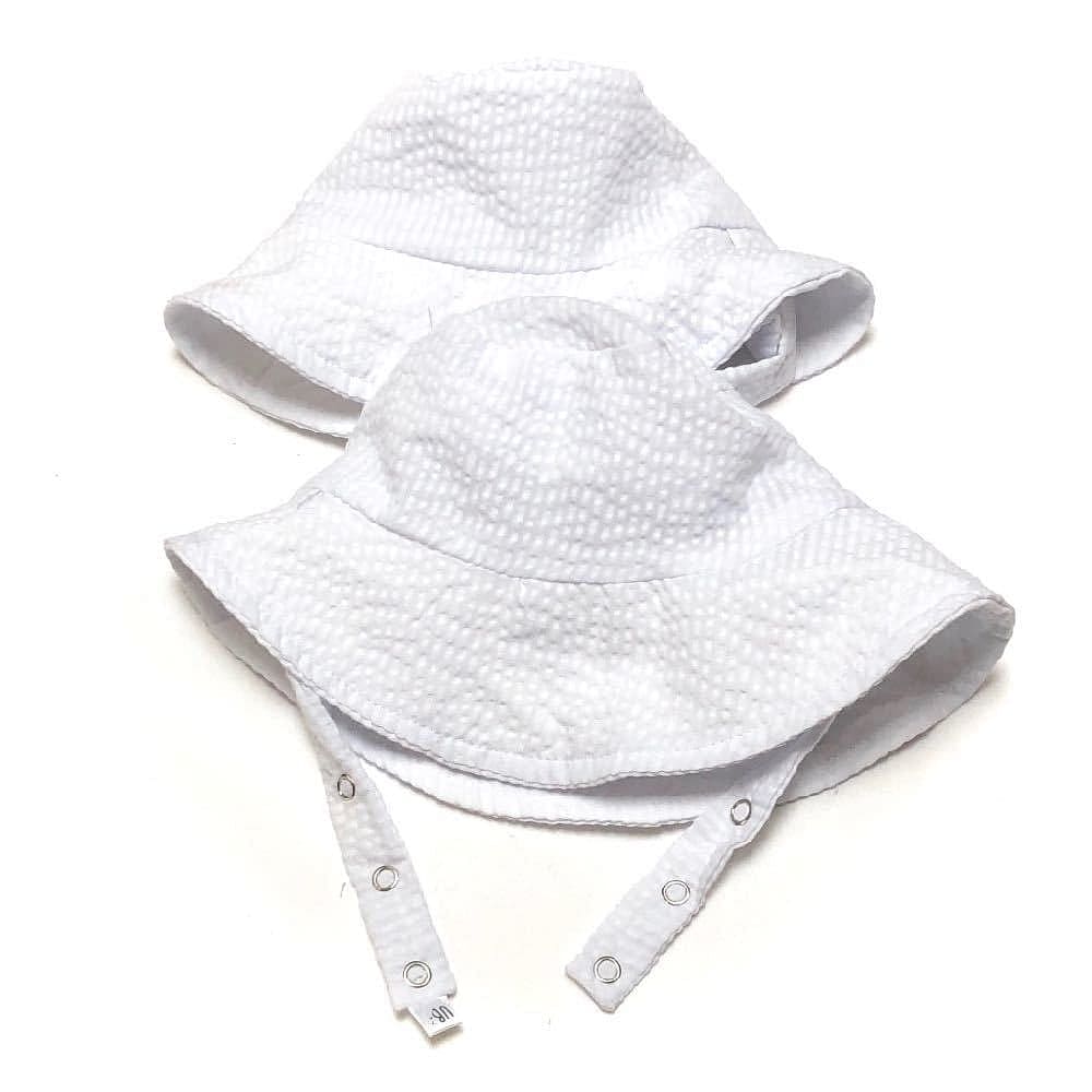 Two white textured bucket hats on a white background