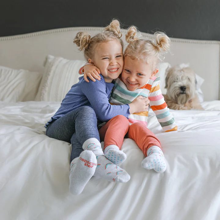 Two kids wearing grey socks that save LGBTQ lives