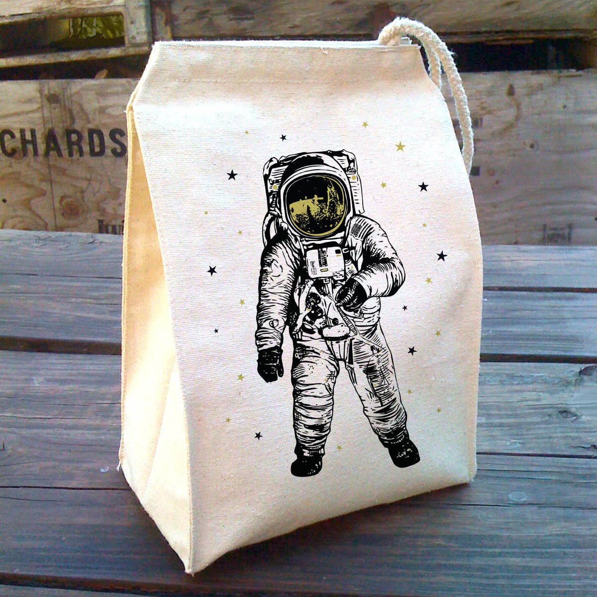 Canvas lunch bag with an astronaut design on a wooden table