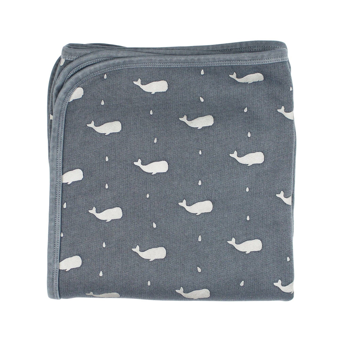Folded blanket with whale pattern on a white background