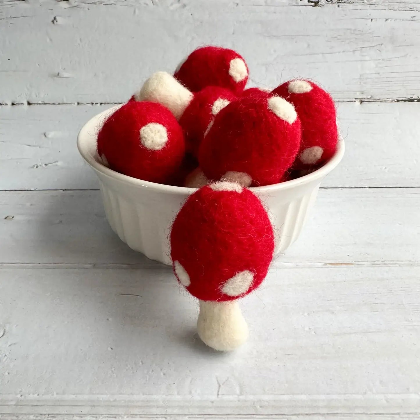 Felt red mushrooms in a bowl