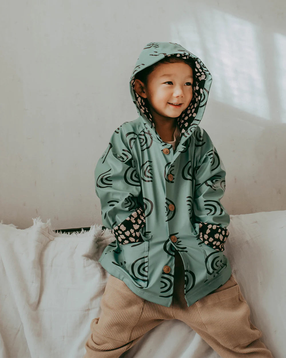 Child wearing a rainbow raincoat