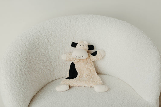 bessie cow sherpa snuggle lovey on a chair