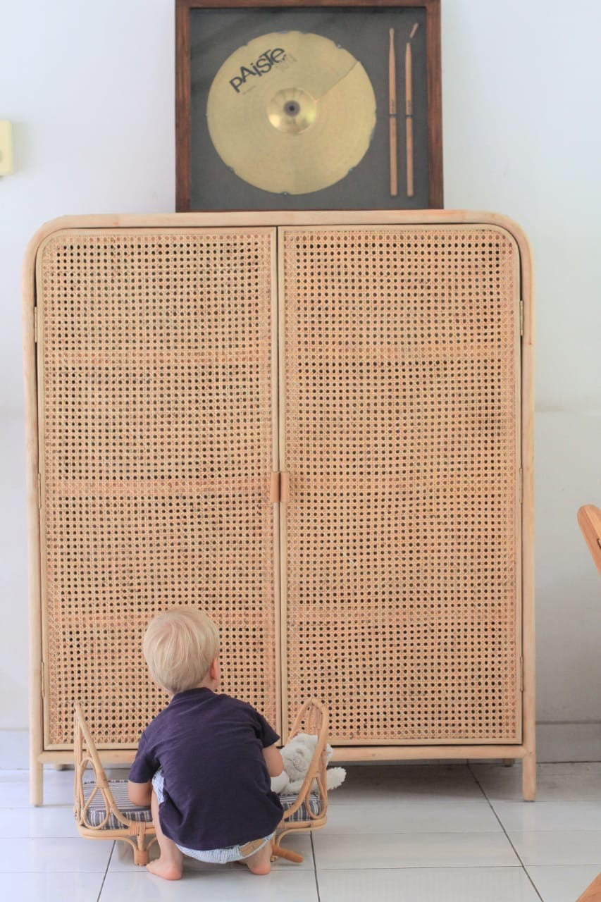 child playing with a stuffie and Poppie Day bed - gold leaves