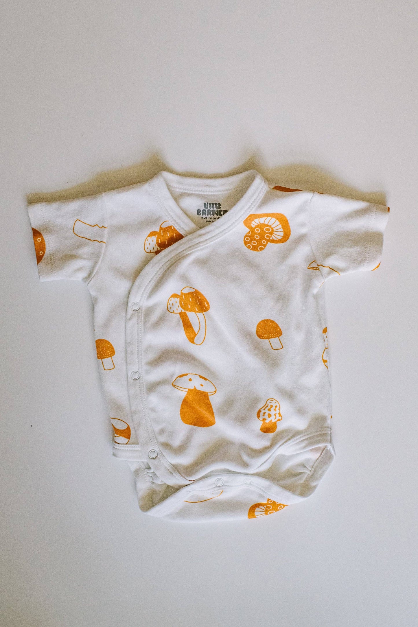 Mushroom baby bodysuit flat lay