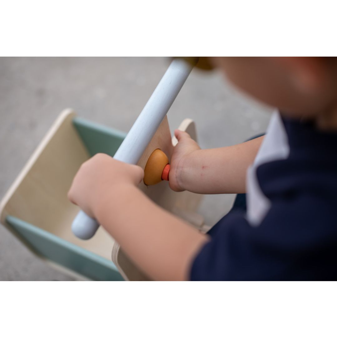 Child playing with a Delivery Bike in Orchard  by plan toys