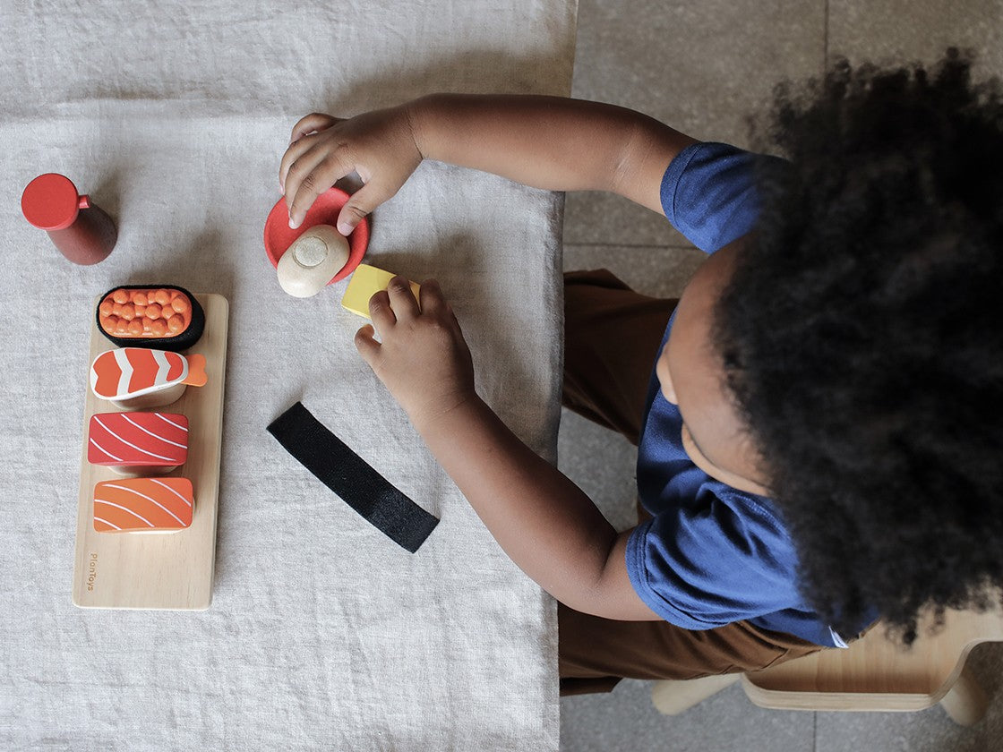 kid playing with Sushi Set Plan Toys