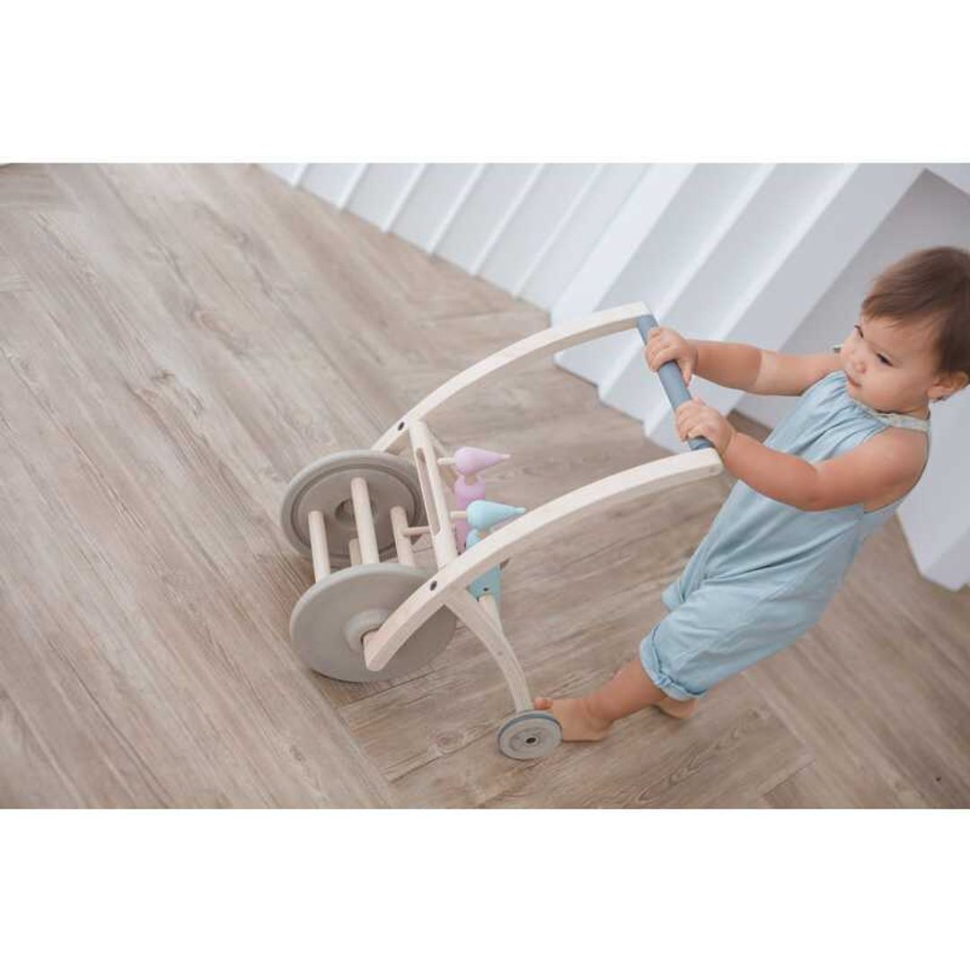 Toddler pushing a Woodpecker Walker BY PLAN TOYS