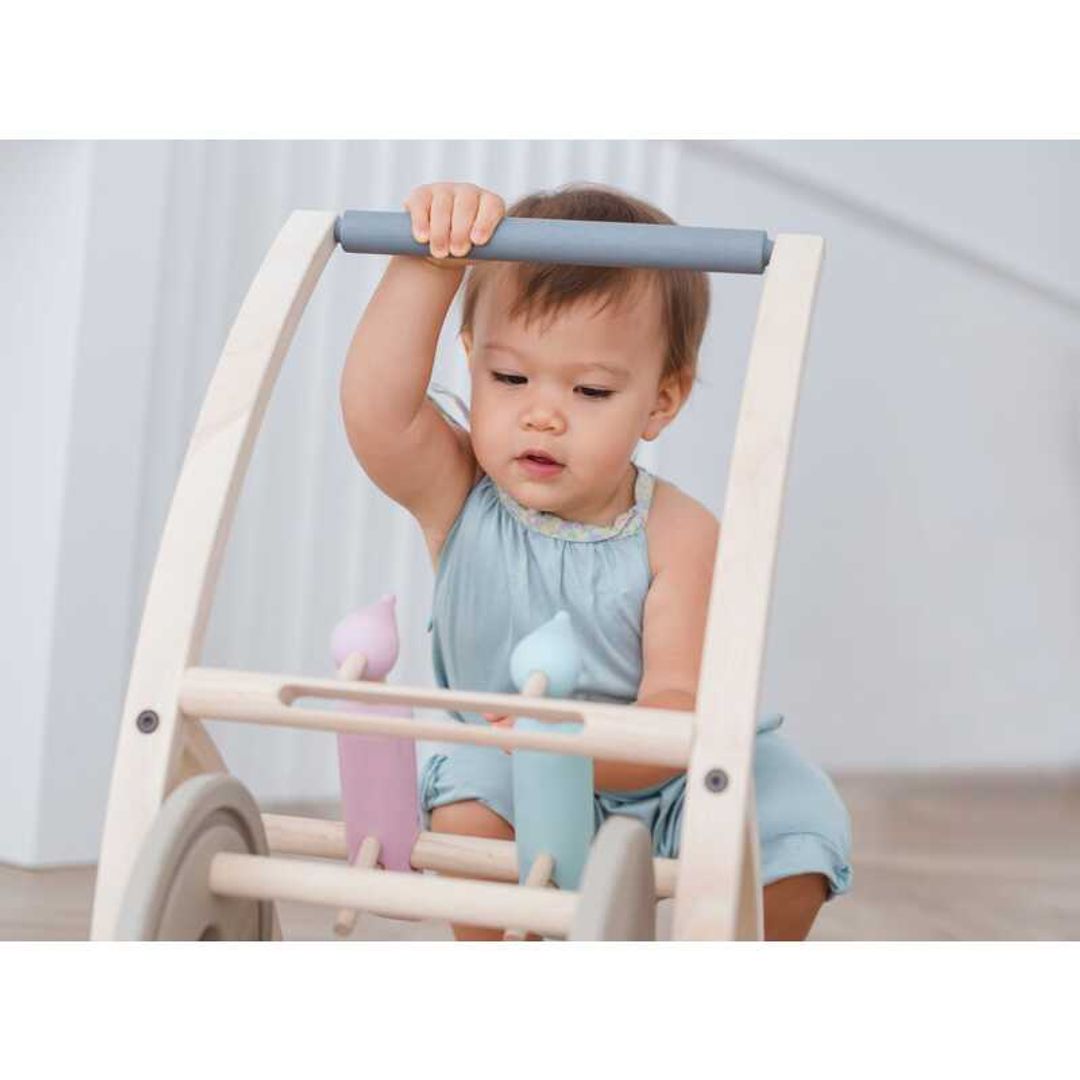 Toddler pushing a Woodpecker Walker BY PLAN TOYS