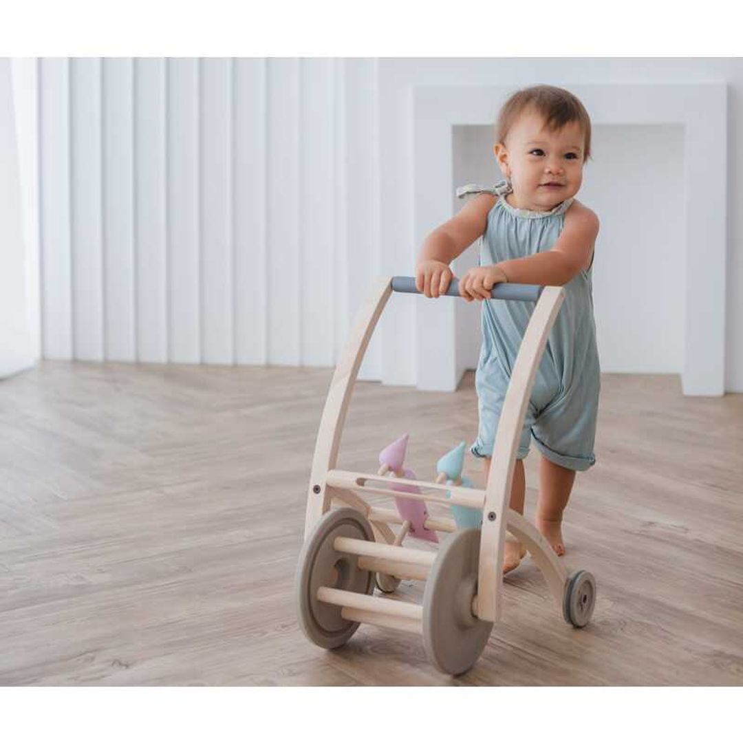 Toddler pushing a Woodpecker Walker BY PLAN TOYS