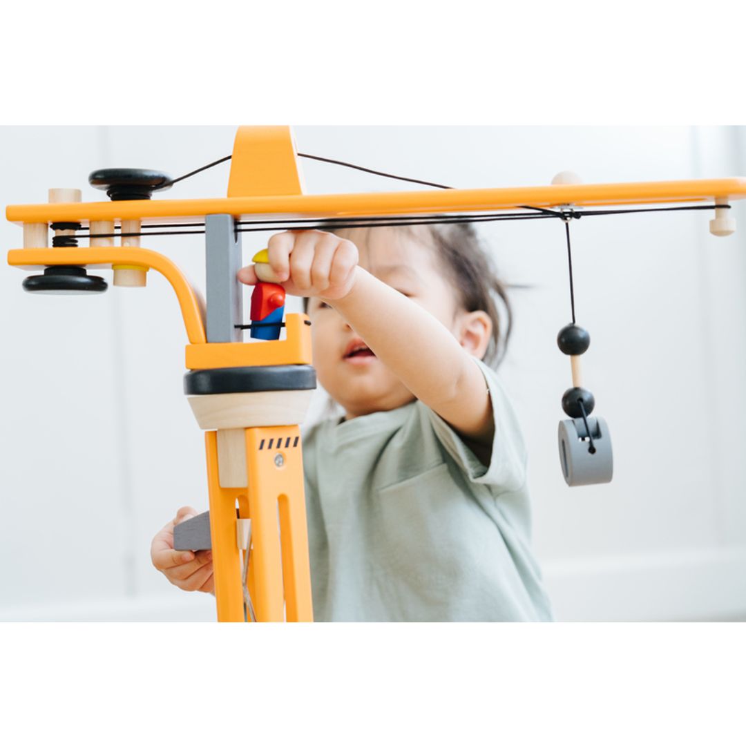 Child playing with Plan Toys Crane Set