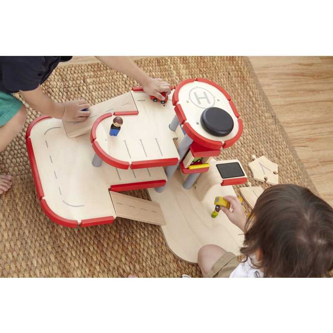 Child Playing with Parking Garage by Plan Toys