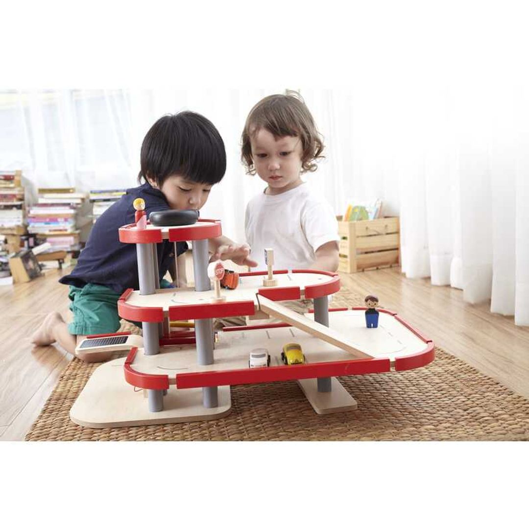 Child Playing with Parking Garage by Plan Toys