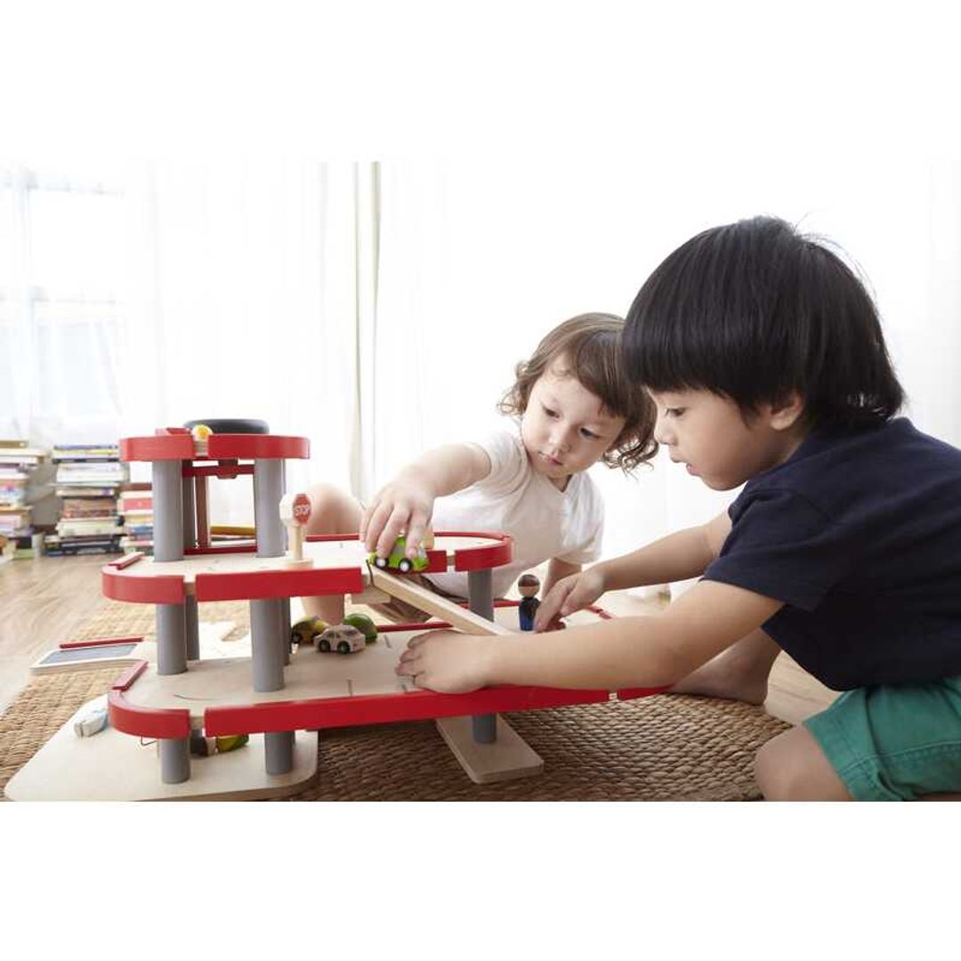 Child Playing with Parking Garage by Plan Toys