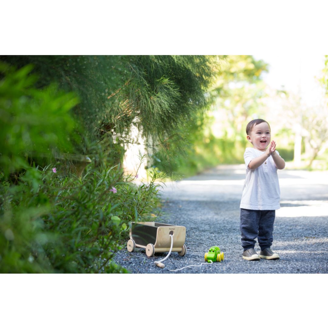 Child playing outside Kids with Black Wagon  by Plan Toys