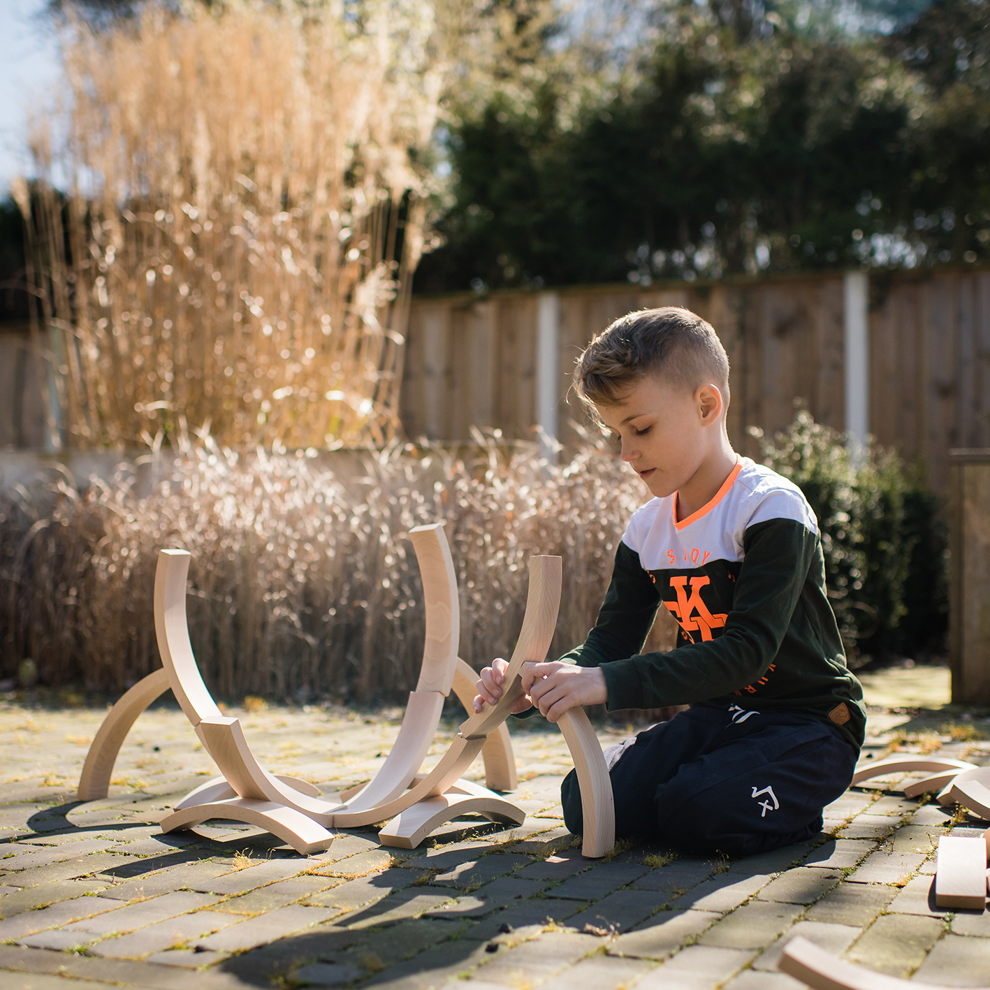 Child playing with Abel Building Blocks outdoors
