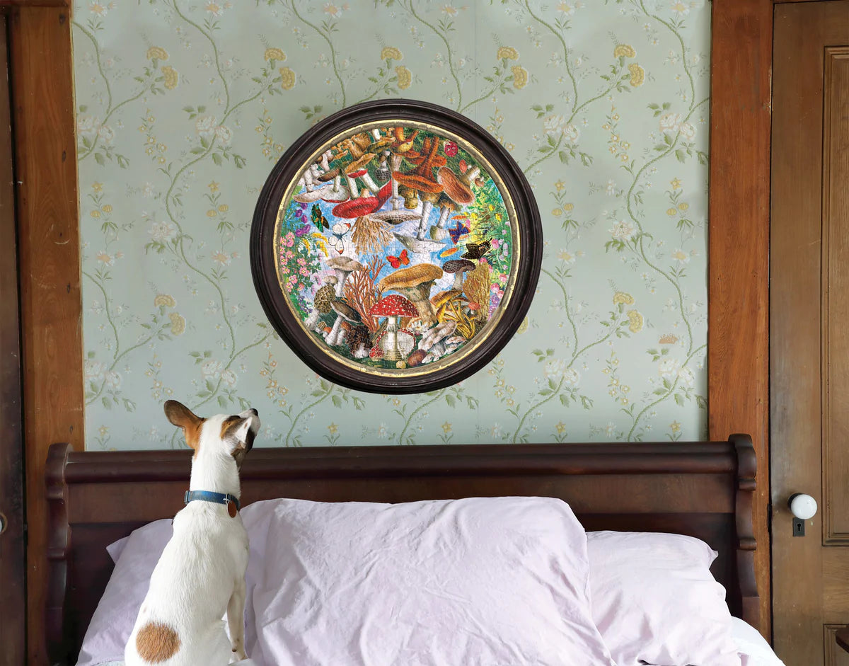 Mushroom and Butterflies 500 Puzzle framed on a wall with a dog looking at it