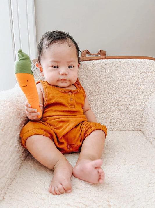 Baby holding organic plush carrot teether by Under The Nile