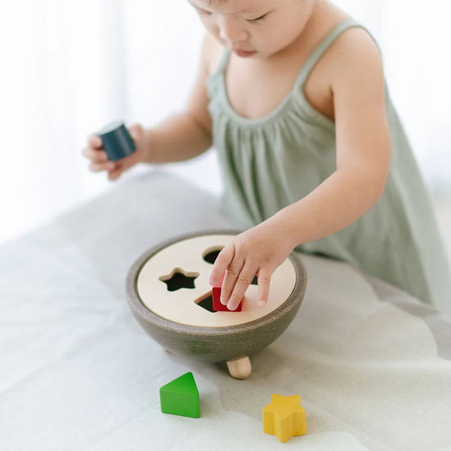 Child playing with shape sorting bowl