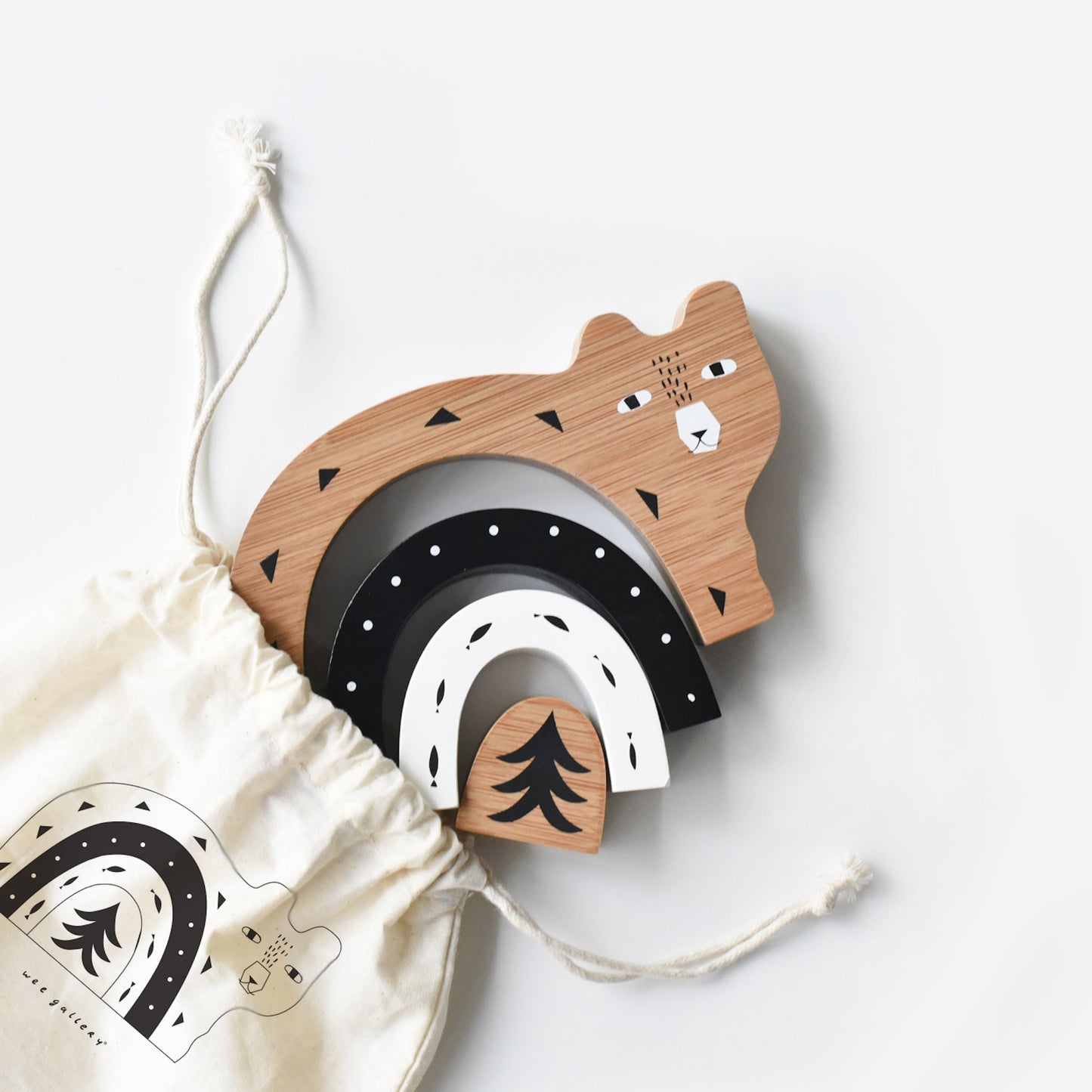 Wooden toy with bear design and rainbow elements on a white background