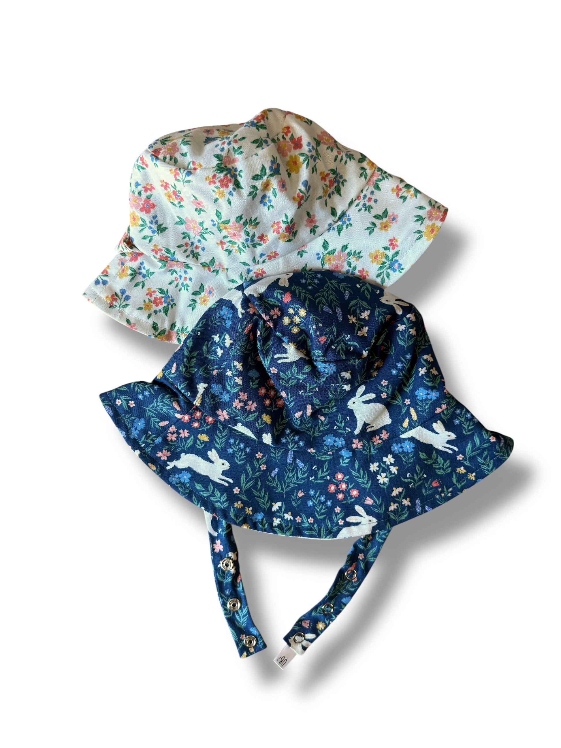 Two floral-patterned sunhats on a white background