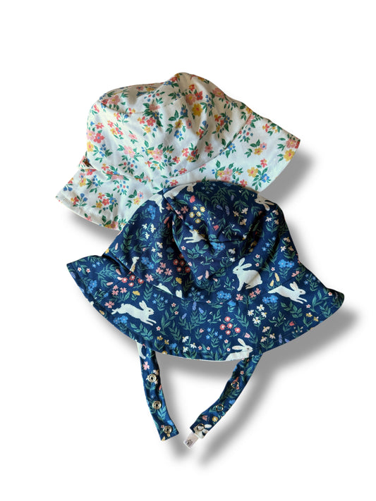 Two floral-patterned sunhats on a white background