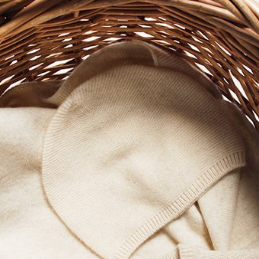 Beige sweater inside a wicker basket