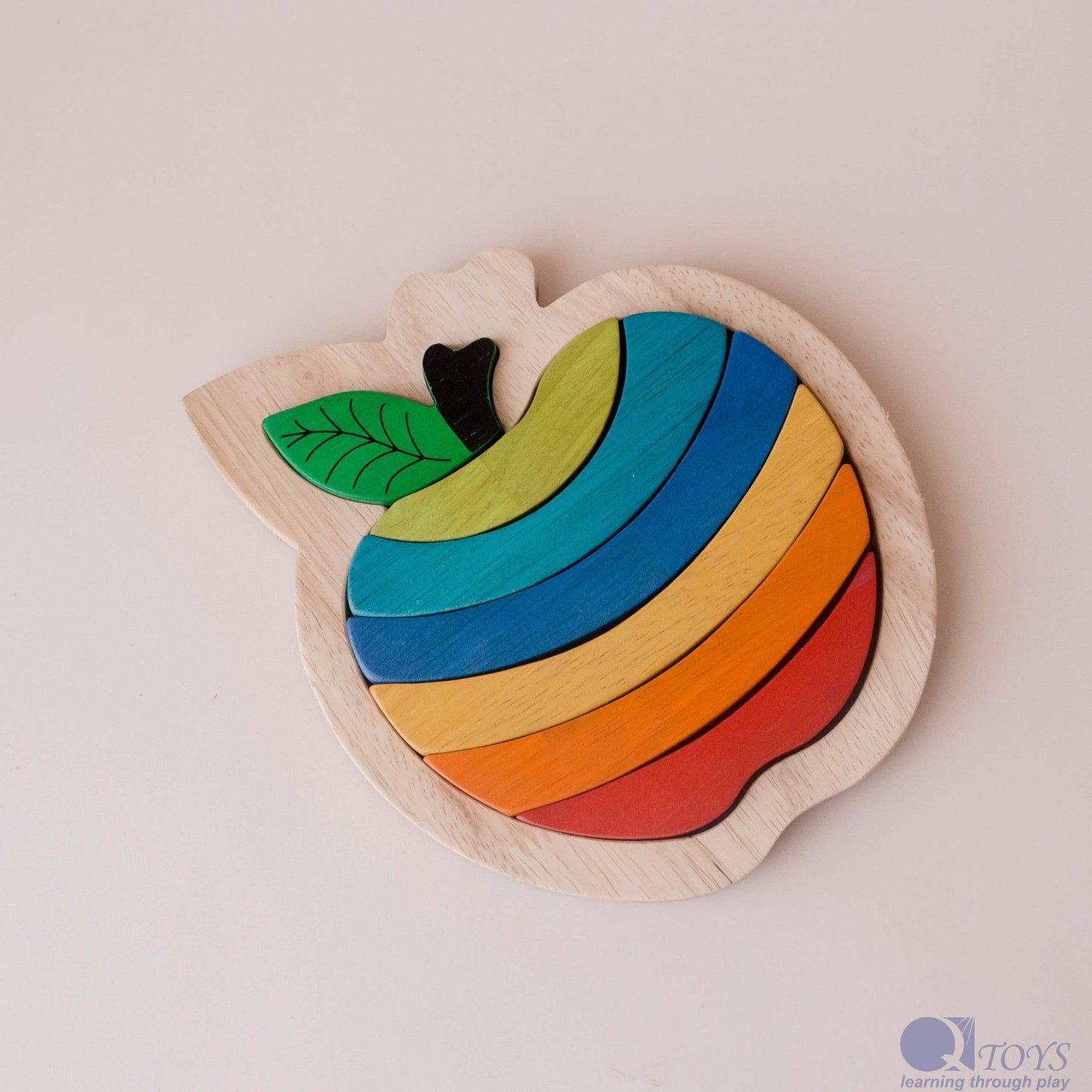 Colorful wooden apple-shaped puzzle toy on a light background
