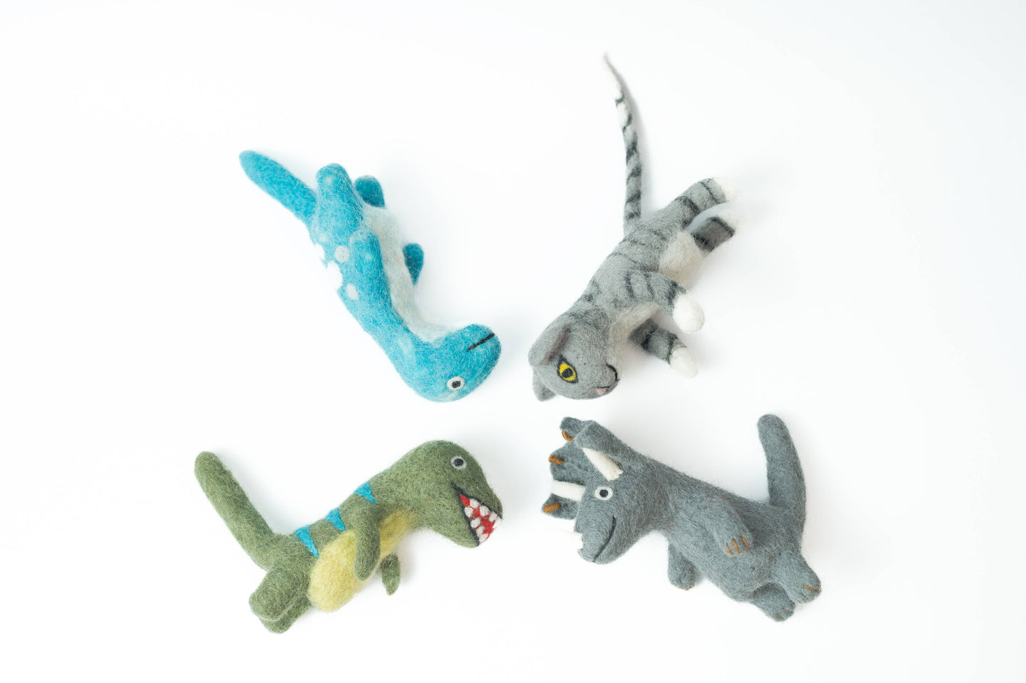 Four toy dinosaurs in different colors on a white background
