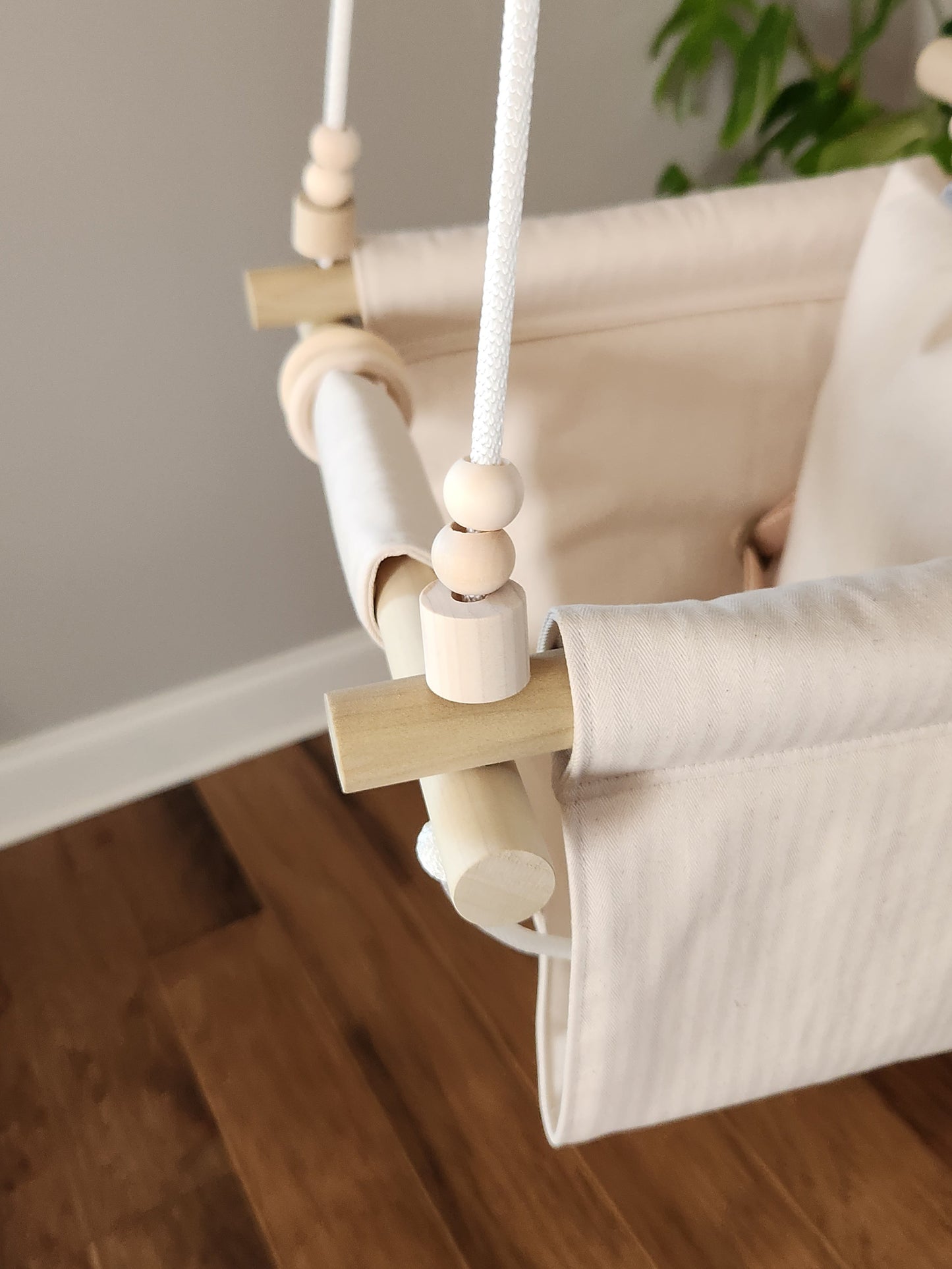 Baby swing with wooden elements on a wooden floor