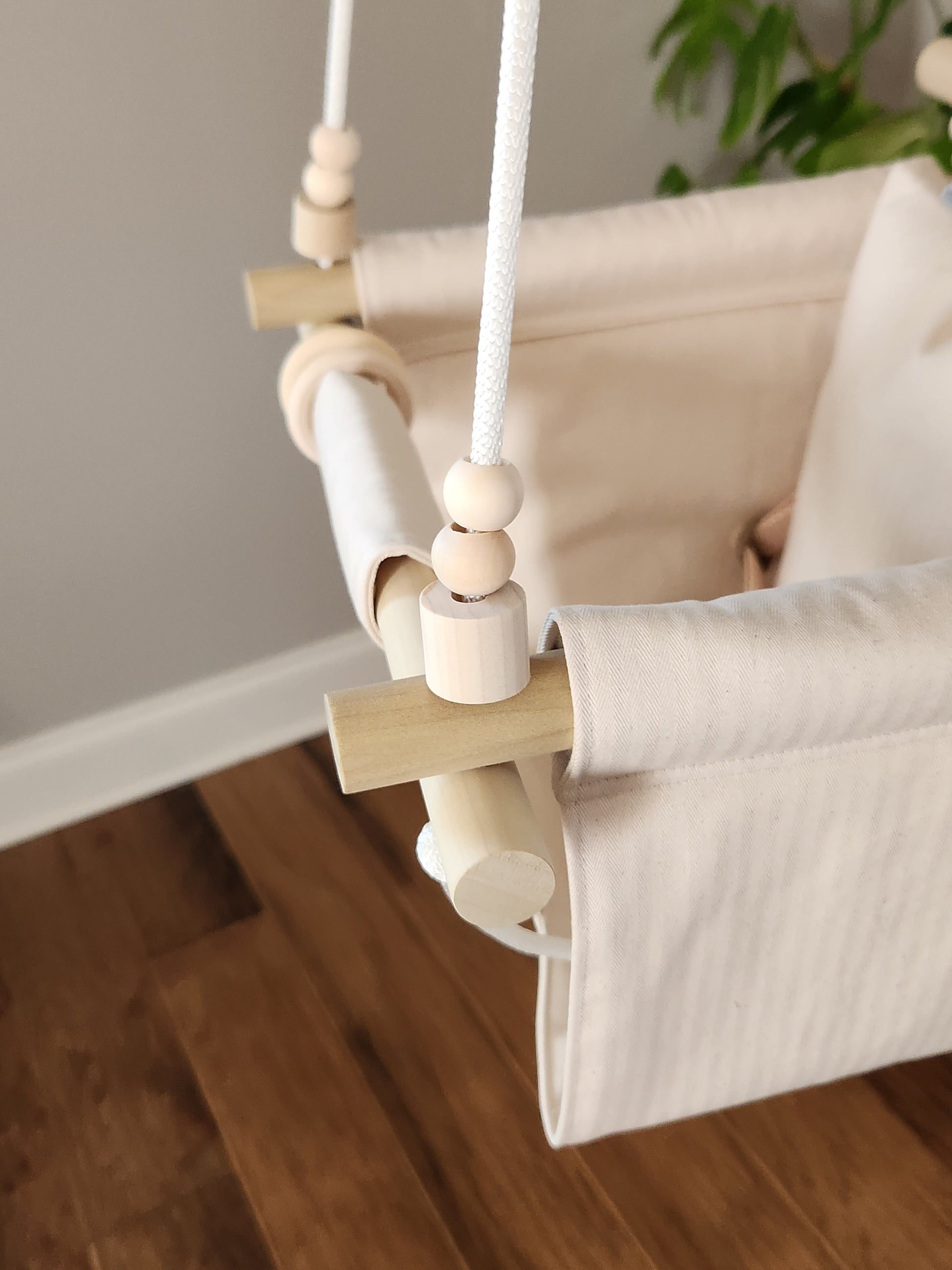 Baby swing with wooden elements on a wooden floor