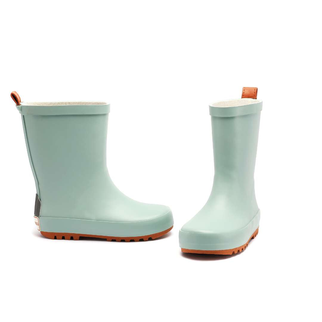 Pair of light blue rain boots with brown soles on a white background