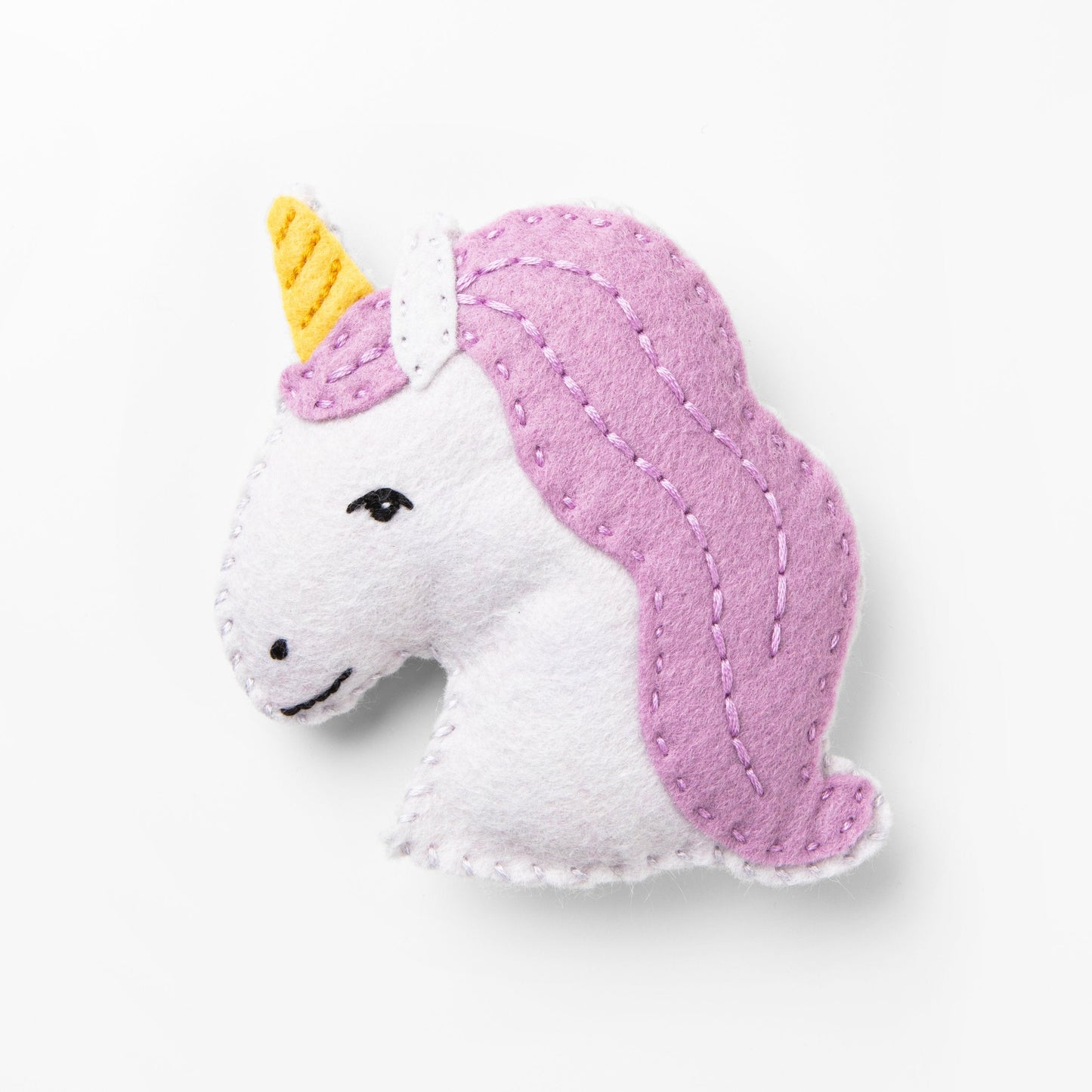 Felt unicorn toy with pink mane and yellow horn on a white background