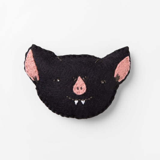 Black cat-shaped plush toy with pink inner ears on a white background