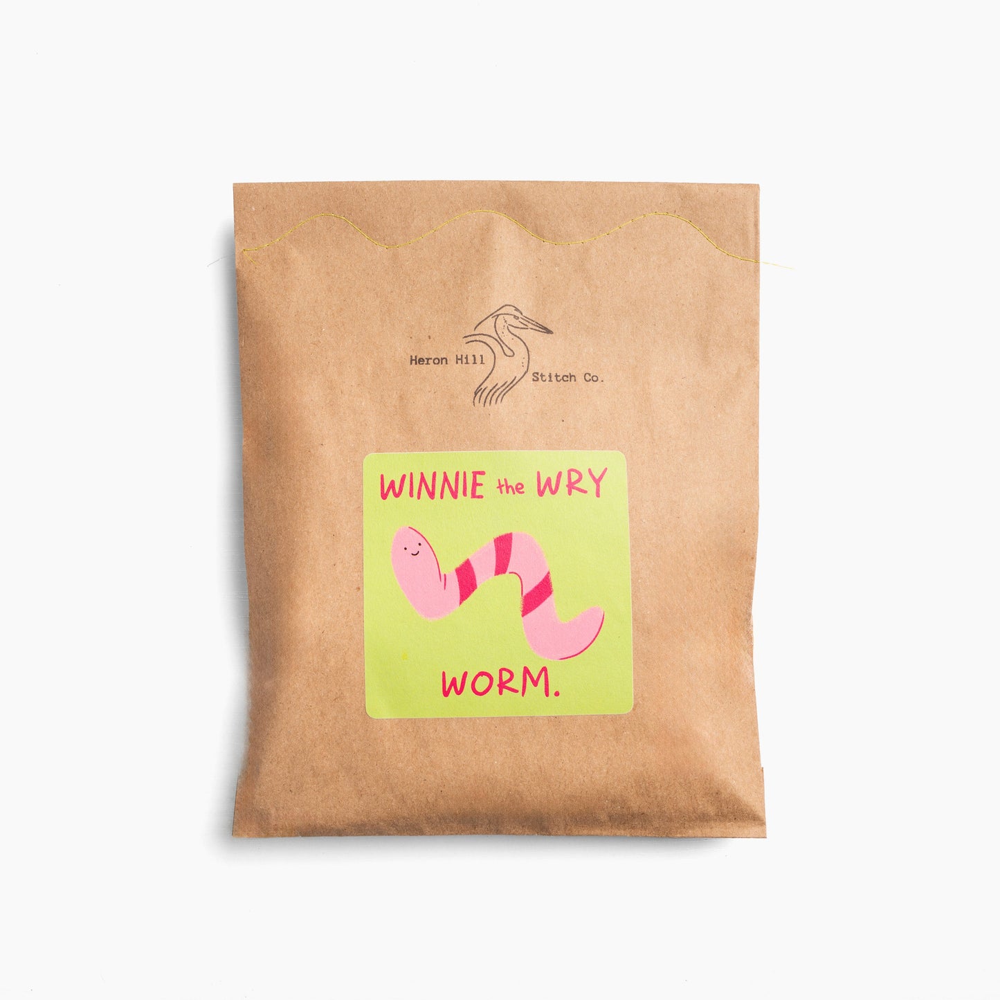 Kraft paper package with a colorful label featuring a worm illustration and text on a white background.
