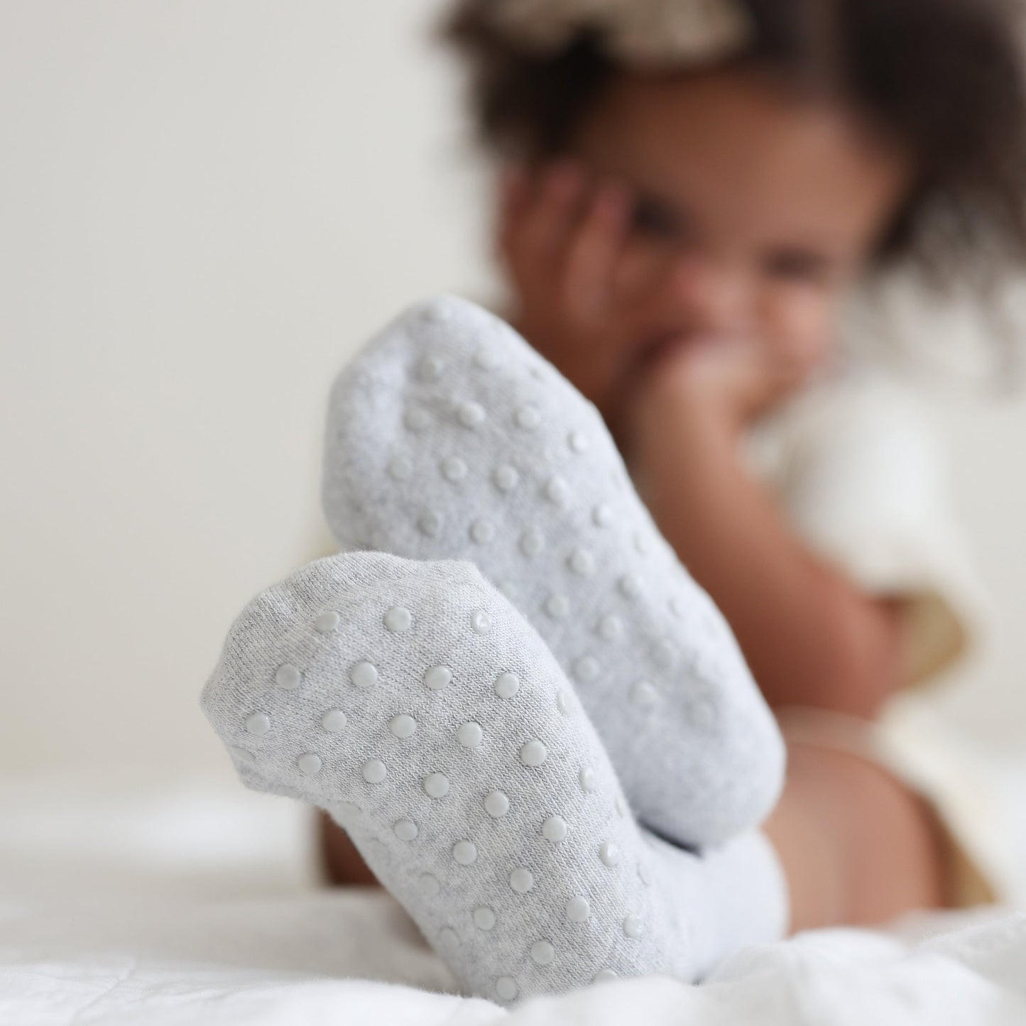 Close-up of baby's feet wearing gray socks with a blurred background
