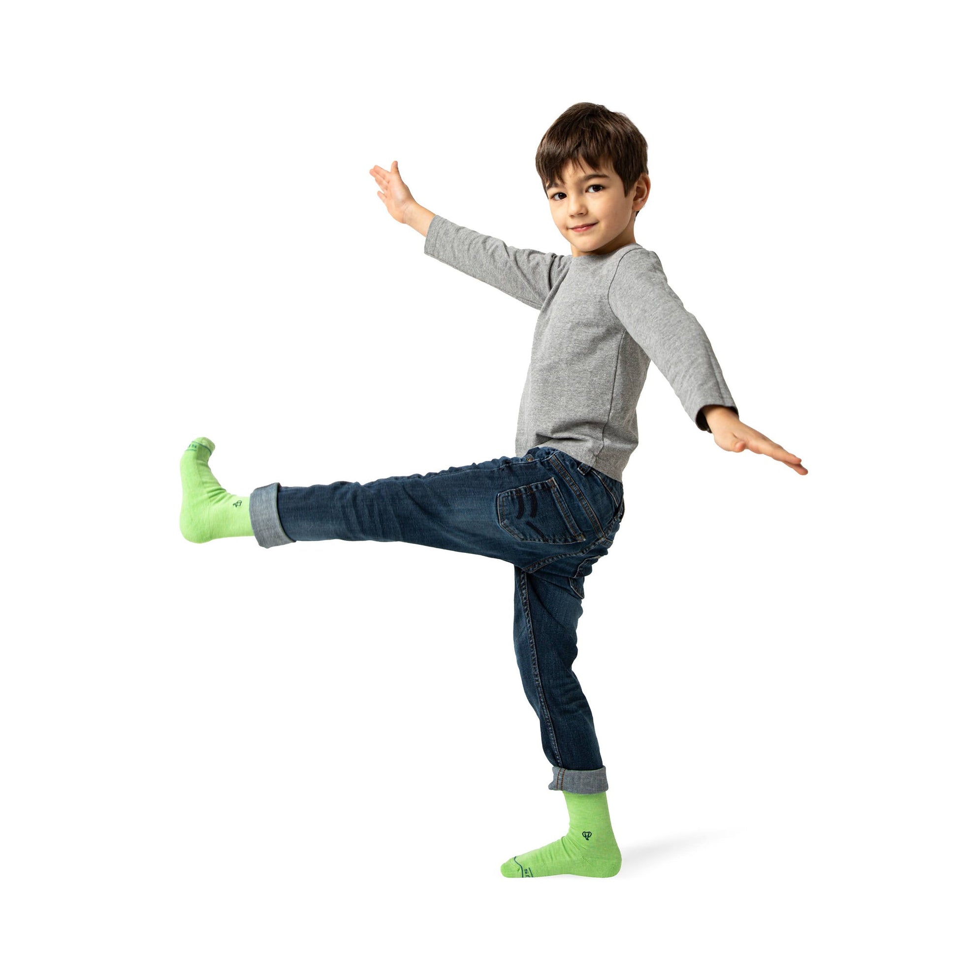 Child wearing green socks and gray shoes on a white background