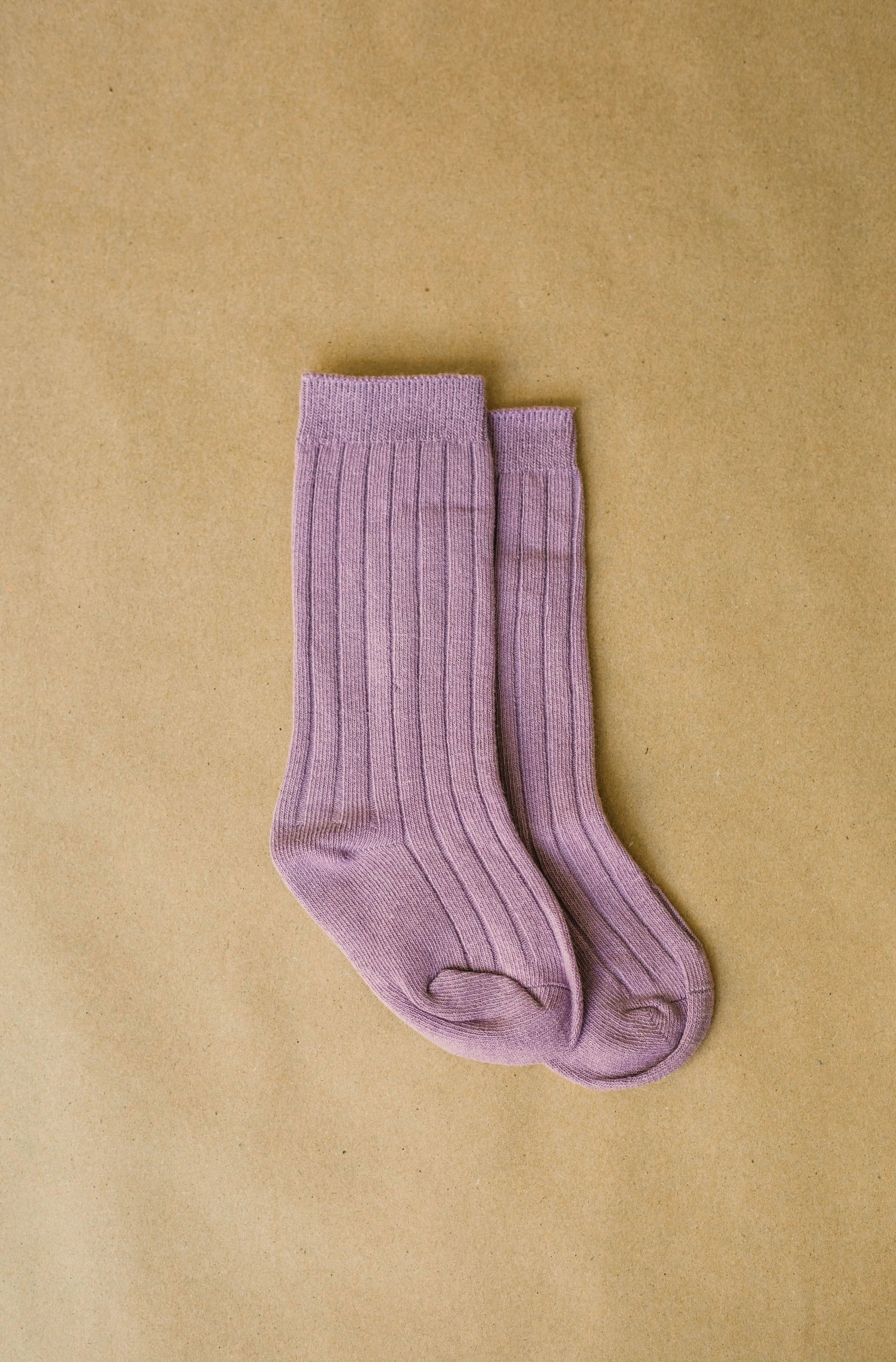 Pair of purple socks on a beige background