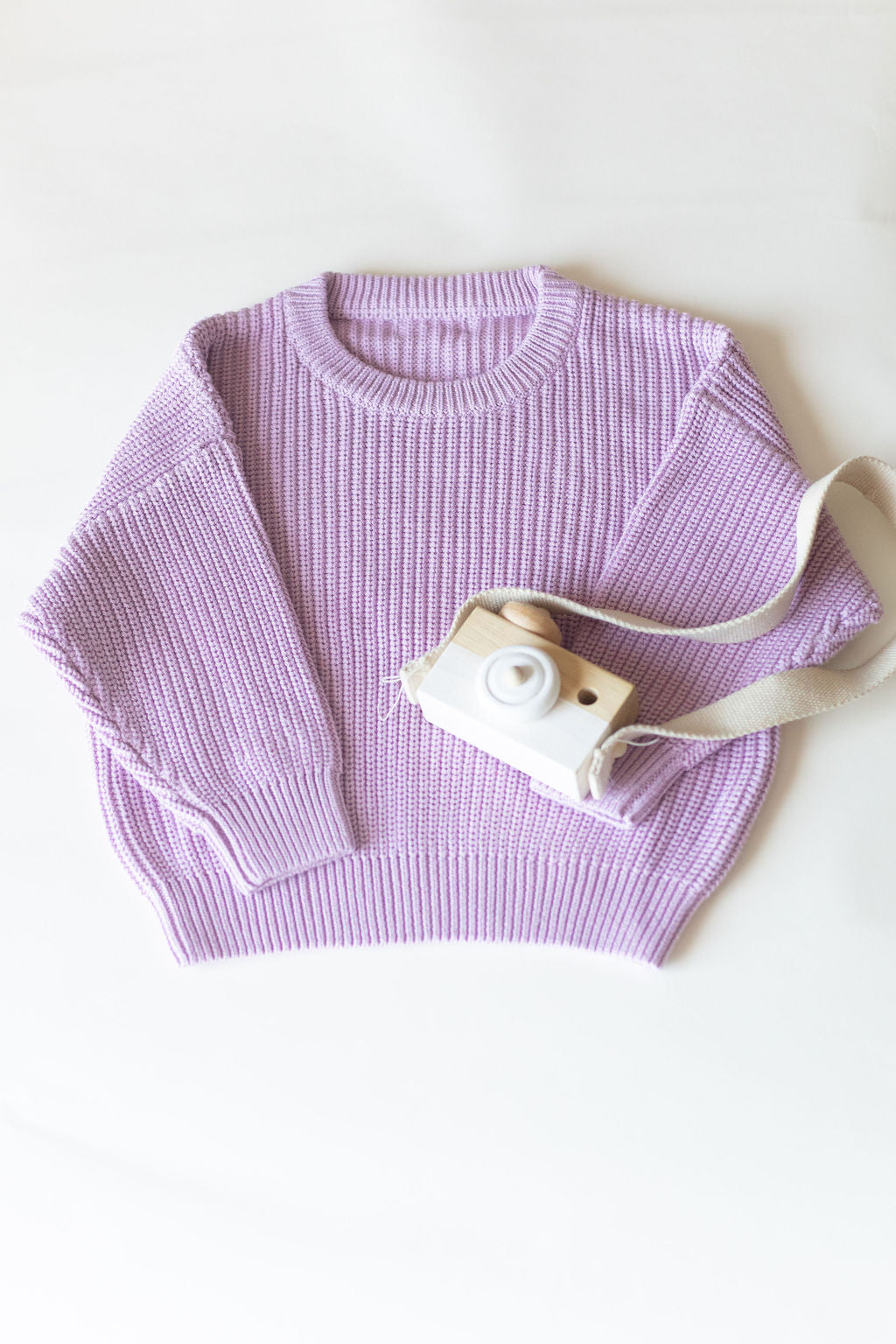 Purple sweater with a camera on a white background