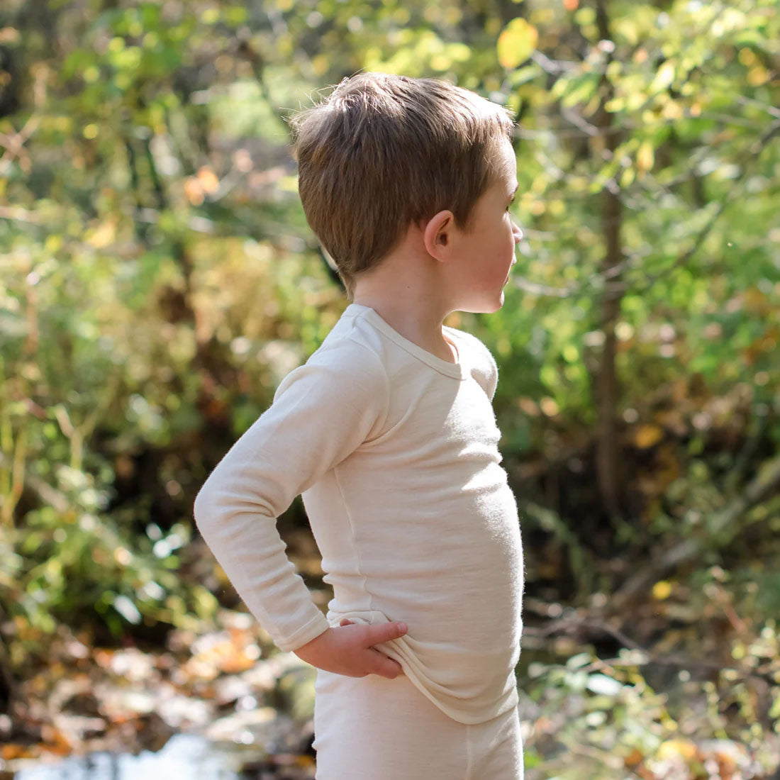 Child looking at tree's wearing a natural long sleeve wool silk short