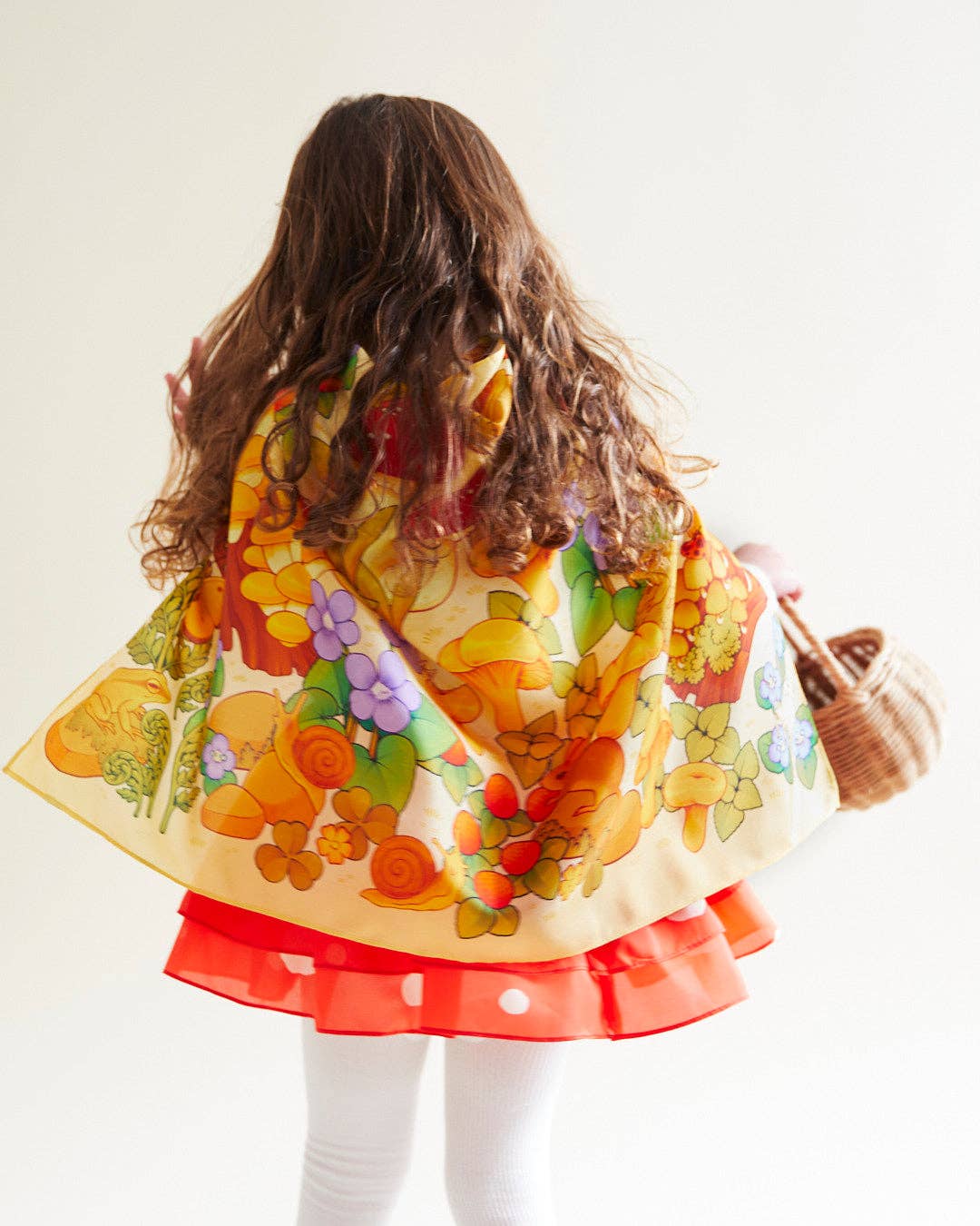 Person wearing a colorful floral dress with a white background