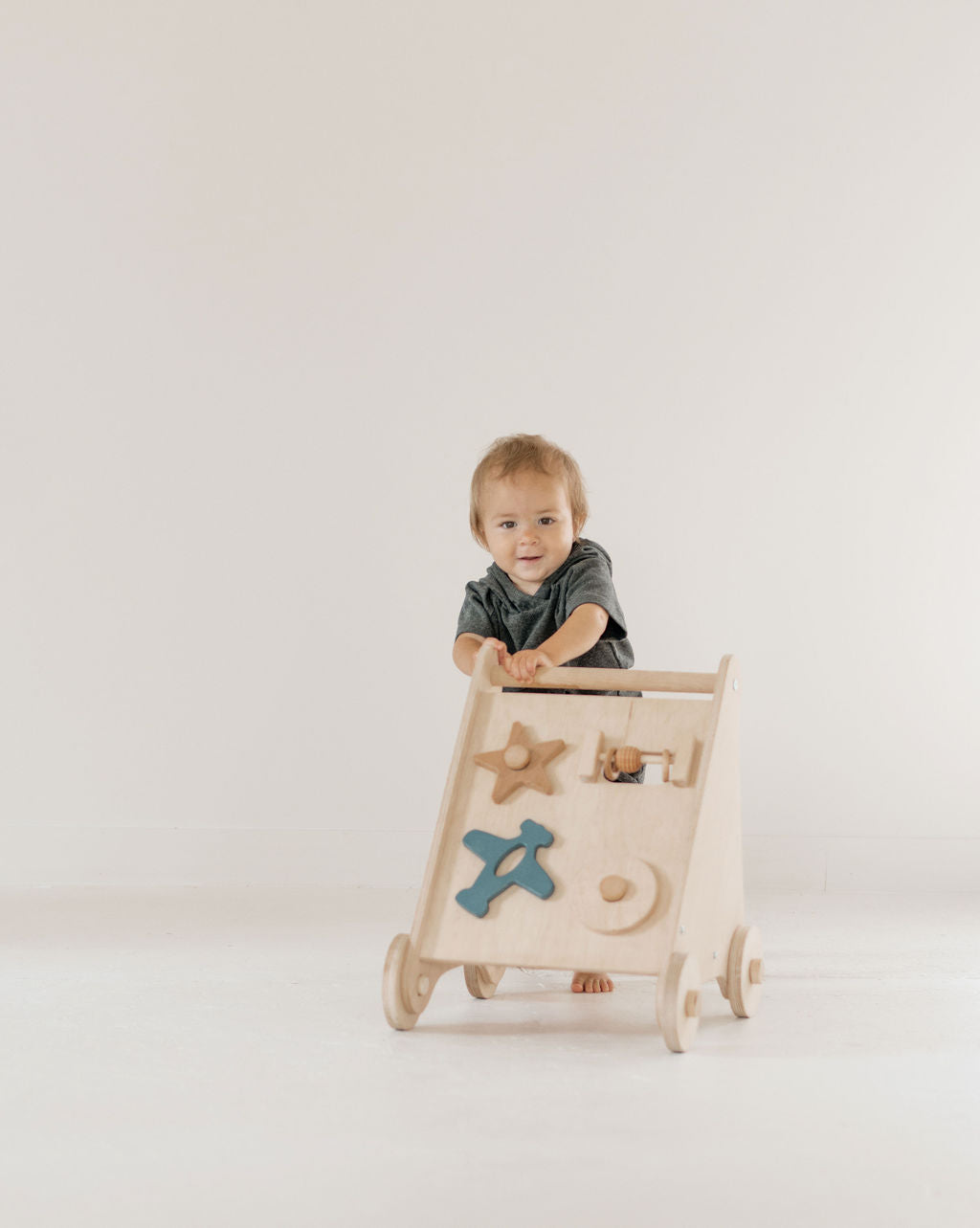 Child playing with a wooden toy on a plain background