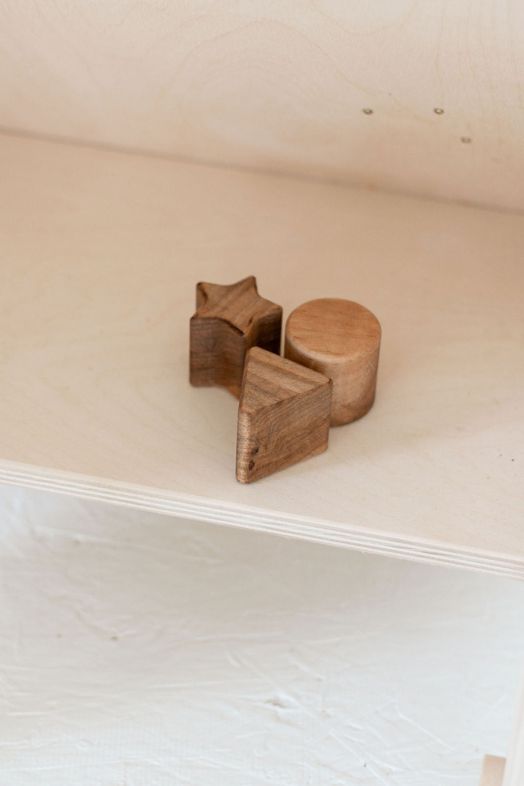 Three wooden star-shaped objects on a white surface