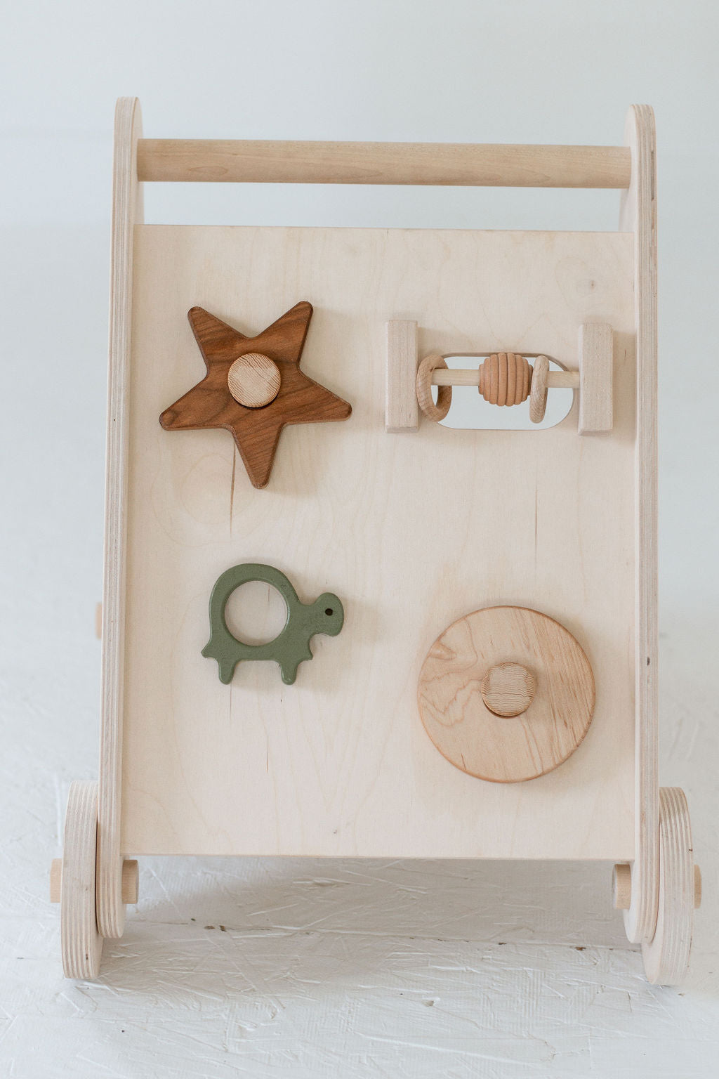 Wooden baby activity center with various shapes on a white background