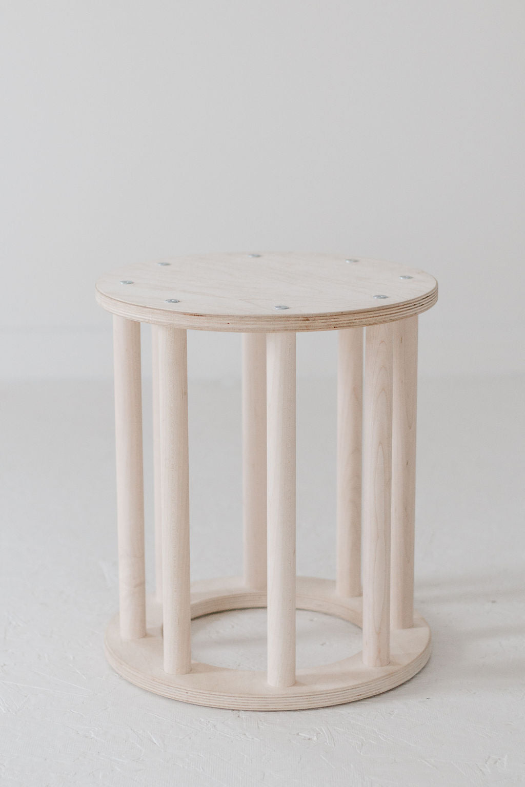 Round wooden side table with a white background