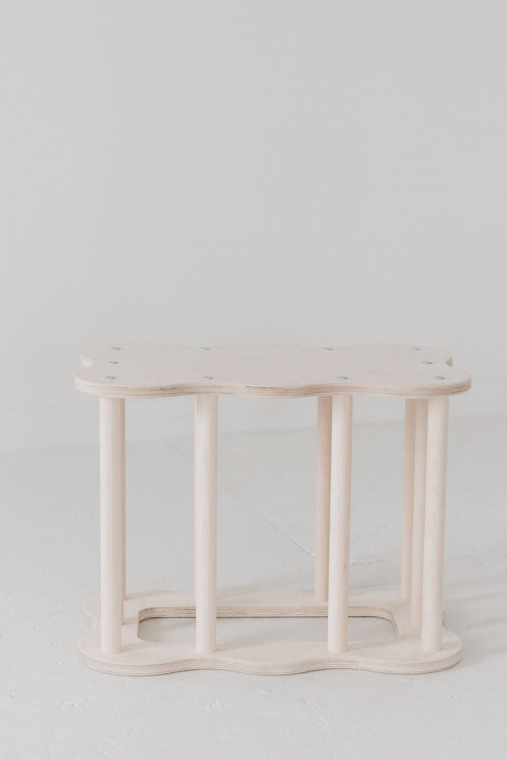 White wicker side table on a light gray background